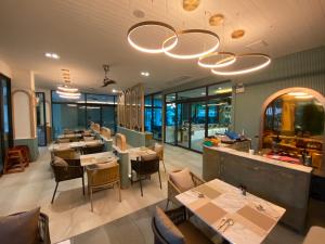 un ristorante con tavoli, sedie e finestre di Infinity Aonang Krabi - SHA Certified ad Aonang Beach