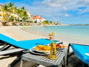 uma mesa com um prato de comida na praia em Curacao Avila Beach Hotel em Willemstad