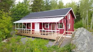 een rood huis met een zwart dak bij Lomahyppäys in Naantali