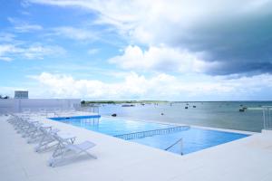 - une piscine avec des chaises et une vue sur l'océan dans l'établissement Watermark Hotel & Resorts Okinawa Miyakojima, à Île Miyako