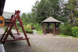 un parque infantil de madera con cenador en un patio en Шале На бе́резі, en Kvasy