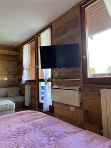 um quarto com uma cama e uma televisão de ecrã plano em Incantevole appartamento stile chalet Breuil Cervinia em Breuil-Cervinia