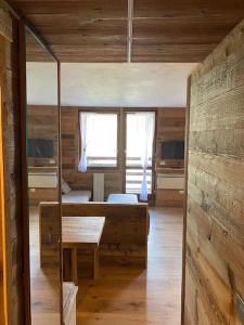 um quarto com uma cama, uma mesa e uma janela em Incantevole appartamento stile chalet Breuil Cervinia em Breuil-Cervinia