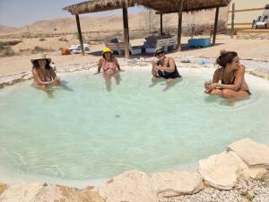 um grupo de mulheres sentadas numa piscina em צימראוון בחוות זית המדבר em Sede Boqer