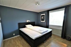 una camera con un letto con una parete blu di RIBO Apartment Arctic a Kiruna