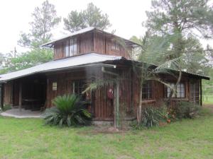 uma pequena casa de madeira com um jardim de relva em Toad Tree Cabins em Sodwana Bay