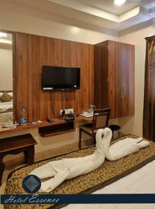 a hotel room with a swan laying on a bed at Hotel ESSENCE in Vellore