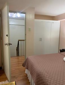 1 dormitorio con 1 cama y puerta corredera de cristal en Affordable 2 BR 2 BA w/ Skycable, Netflix, & Amazon Prime en Manila