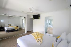 BLK Stays Guest House Deluxe Units Bellmere tesisinde bir odada yatak veya yataklar