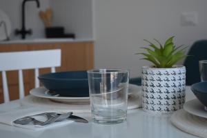 ein Glas Wasser auf einem Tisch mit Teller und Schüsseln in der Unterkunft Il Grande Blu in Terracina