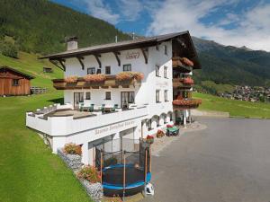 ein großes weißes Gebäude neben einem Wasserkörper in der Unterkunft Landhaus Strolz in Sankt Anton am Arlberg