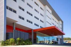 ein Bürogebäude mit einer rot-weißen Fassade in der Unterkunft Hotel Darolt Criciúma in Criciúma