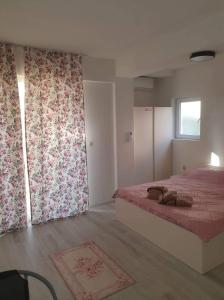 een slaapkamer met een bed met roze gordijnen en een raam bij Cavleski rooms in Prilep