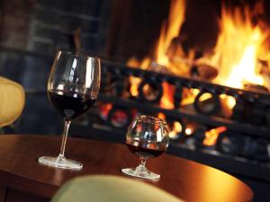 two glasses of wine sitting on a table in front of a fireplace at Letchworth Hall in Letchworth