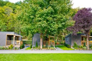 una casa con un jardín y un árbol en Chalet Fuusslee en Goebelsmuhle