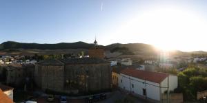 un antiguo edificio con una torre de reloj en una ciudad en Apartamentos Eneriz en Enériz