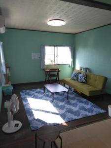 a living room with a couch and a rug at Minami Onna Tropical in Onna