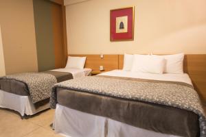 Tempat tidur dalam kamar di Hotel Porto Real Aparecida