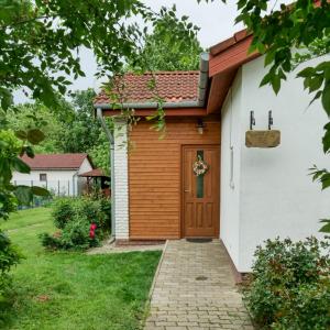 una casa con una puerta de madera en un patio en Cseresznyés Apartman en Berekfürdő