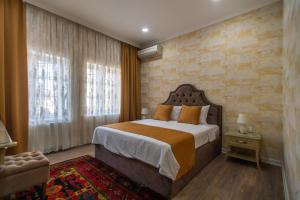 - une chambre avec un grand lit et un mur en briques dans l'établissement NAR BOUTIQUE HOTEL, à Baku