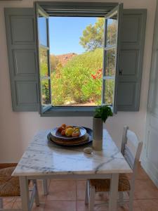 einen Tisch mit einem Obstteller vor einem Fenster in der Unterkunft PATMOS Confidential in Patmos