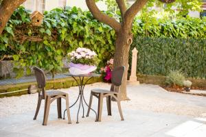 uma mesa com duas cadeiras e um vaso de flores em Casa Lollobrigida em Ciampino