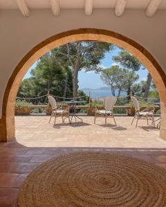 eine Terrasse mit Stühlen und einem Tisch mit Aussicht in der Unterkunft Villa Dora (Only adults) in Jávea