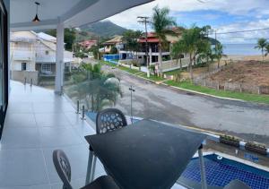 een balkon met een tafel en uitzicht op een straat bij Flats Catamarã in Angra dos Reis