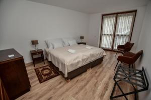 a bedroom with a bed and two chairs in it at Bodrog33 Riverhouse in Tokaj