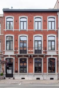 un gran edificio de ladrillo rojo con ventanas y balcones en Vinotel X en Tongeren