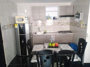 małą kuchnię ze stołem i lodówką w obiekcie Apartamento acogedor con Piscina Excelente Sector w mieście Ibagué