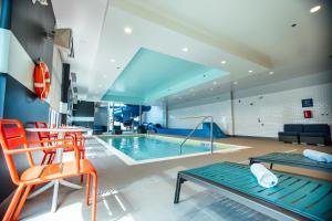 uma piscina num quarto com cadeiras laranja em Tru By Hilton Yarmouth, Ns em Yarmouth