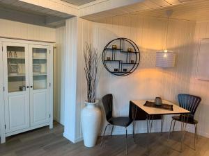 ein Esszimmer mit einem Tisch und einer Vase in der Unterkunft Notodden Sentrum Apartment NO 1 in Notodden