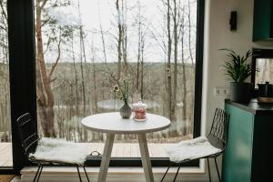 una mesa y dos sillas frente a una ventana en Birštonas Tiny Hemp House en Birštonas