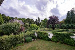 un jardín con un estanque, un banco y árboles en Altstadt Apartment en Goslar