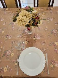 una mesa con un plato y un ramo de flores en Sobrado 4 amplo e confortável em condomínio en Corumbá