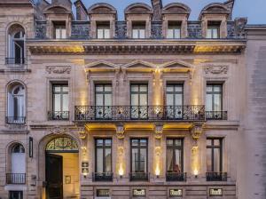 un edificio con puerta amarilla y balcón en Le Palais Gallien Hôtel & Spa en Burdeos