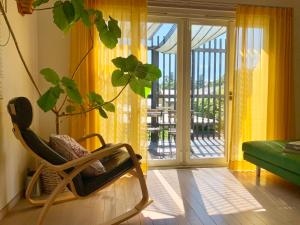 mecedora en una sala de estar con puerta corredera de cristal en Kamakura Vacation House en Kamakura