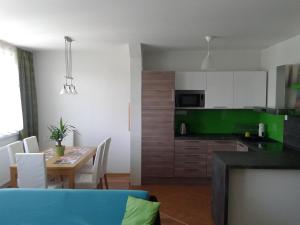 eine Küche und ein Esszimmer mit einem Tisch und Stühlen in der Unterkunft Apartmán Liptov in Lúčky