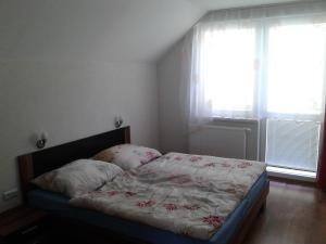 ein kleines Schlafzimmer mit einem Bett mit Blumen darauf in der Unterkunft Apartmán Liptov in Lúčky