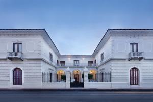 un grand bâtiment blanc avec un portail dans l'établissement Hotel la Perla Leon, à León