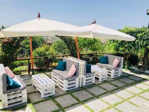 - un groupe de chaises blanches et un parasol dans l'établissement Villa Aurora, à Villanova del Battista