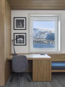 - un bureau avec une fenêtre et une chaise dans la chambre dans l'établissement Radisson Blu Hotel Tromsø, à Tromsø