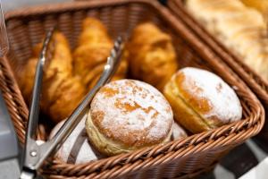 Una cesta llena de donuts con pinzas. en Skyhotel Prague en Praga