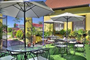 an outdoor patio with tables and chairs and umbrellas at Hotel Elzet in Tábor