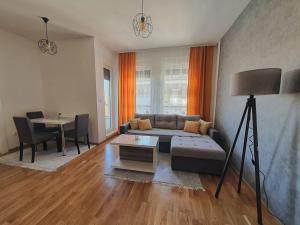 salon z kanapą i stołem w obiekcie Zara 1 Apartman w mieście Bijeljina