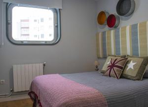 een slaapkamer met een bed en een raam bij Apartamento Dúplex Estación Manzaneda in Ourense