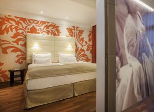 un dormitorio con cama y una pintura de una novia en Boutique Hotel Das Tigra, en Viena