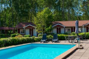 une maison avec une piscine en face d'une maison dans l'établissement Hotell Miskarp, à Mjölby