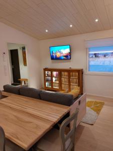 uma sala de estar com um sofá e uma televisão na parede em Arctic River Chalet em Rovaniemi